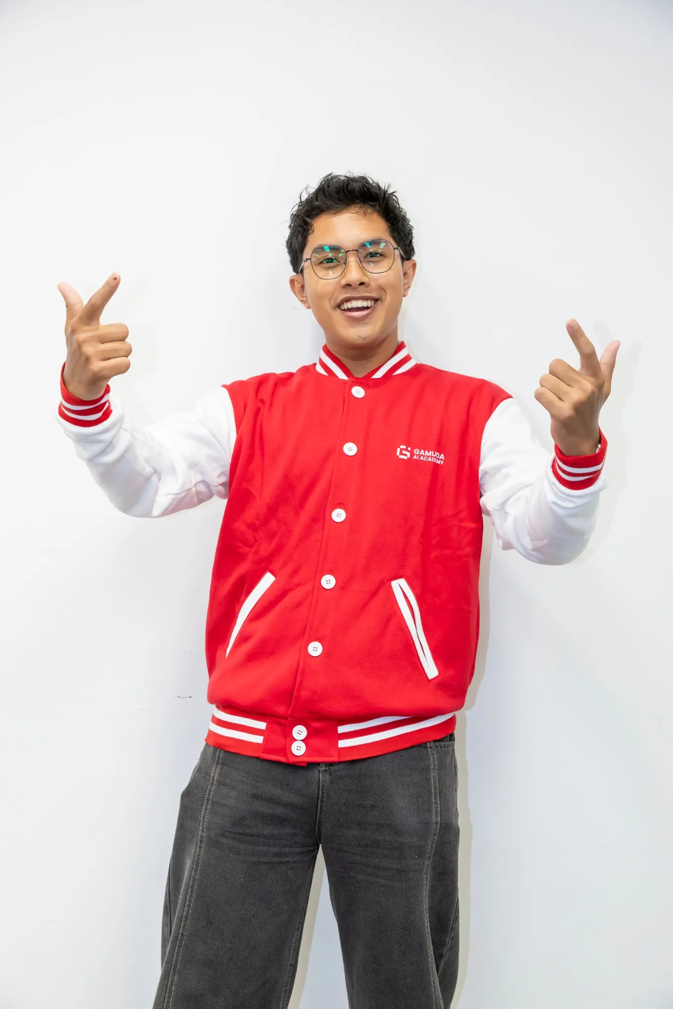 Irham smiling in a red Gamuda AI Academy varsity jacket